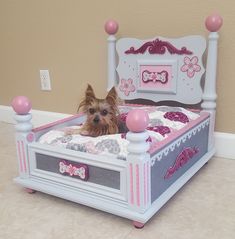 a small dog laying in a pink and white bed