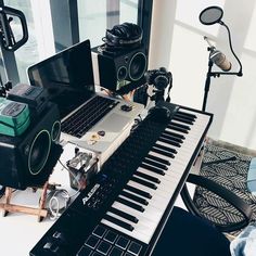 a laptop computer sitting on top of a keyboard next to a sound board and speakers