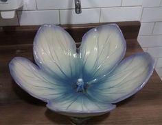 a blue flower sitting on top of a wooden counter