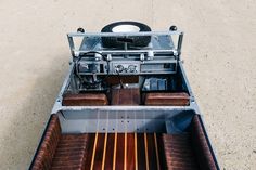 the inside of a vehicle with leather seats and steering wheel on concrete floored area