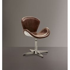 a brown leather chair sitting on top of a wooden table next to a gray wall