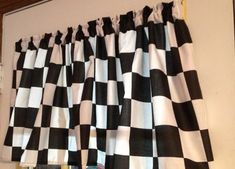 a black and white checkered curtain hanging on the side of a window sill