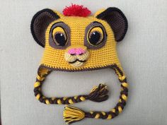 a crocheted lion hat with a red pom - pom on top