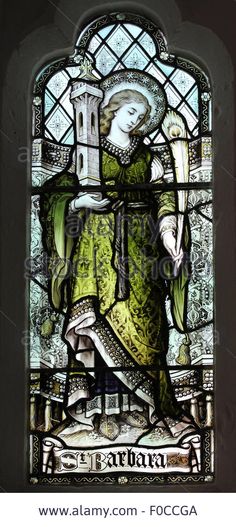 an old stained glass window with a woman holding a bird in her hand and wearing a green dress