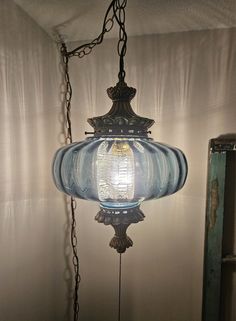 an old fashioned light hanging from a chain