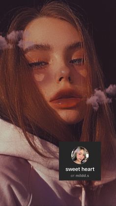 a woman with long hair wearing a white hoodie and clouds in her hair is looking at the camera