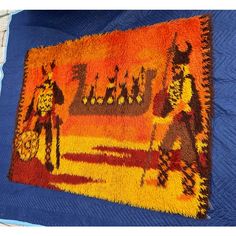 an orange and blue rug with two people on it