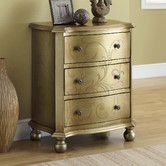 an ornate gold chest of drawers next to a vase and framed photograph on the wall