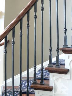 a set of stairs with wooden handrails and blue carpet