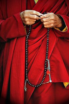 an image of a man in red robes with his hands on his chest and the words,