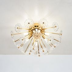 a chandelier that is hanging from the ceiling with clear glass flowers on it