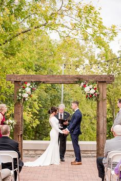 a bride and groom standing at the alter during their wedding ceremony in front of an arbor