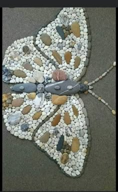 a butterfly made out of rocks and pebbles