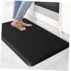 a person standing on a mat in front of an oven with their feet propped up