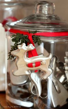 a glass jar filled with silver and red christmas decorations