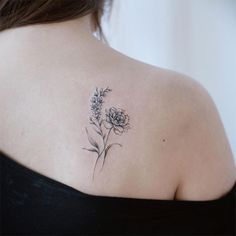 a woman with a tattoo on her back shoulder and flowers in the upper part of her arm