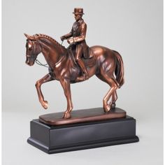 a bronze statue of a man riding a horse on a black base with a white background