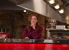 a woman sitting at a counter in a restaurant