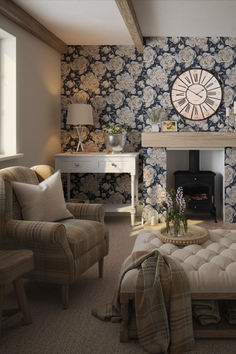 a living room filled with furniture and a clock on the wall above it's fireplace