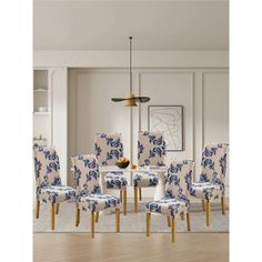 a dining room set with blue and white upholstered chairs in front of the table