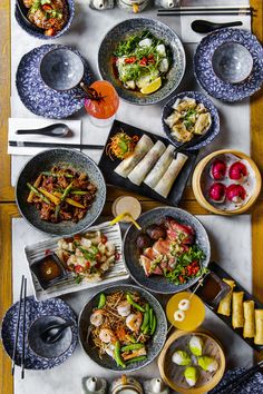 a table topped with plates and bowls filled with different types of food on top of it