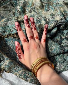 a woman's hand with red and white paint on it, resting on a blanket