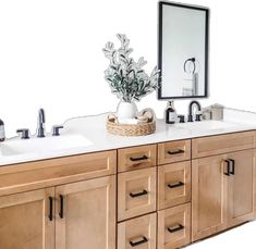 a bathroom vanity with two sinks and a large mirror above it, along with a plant in a basket