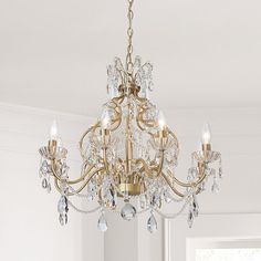 a chandelier hanging from the ceiling in a room with white walls and windows