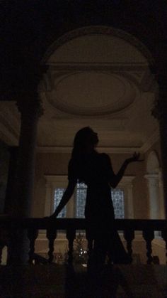 a woman standing on top of a balcony in the dark