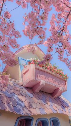 a pink house with flowers on the roof