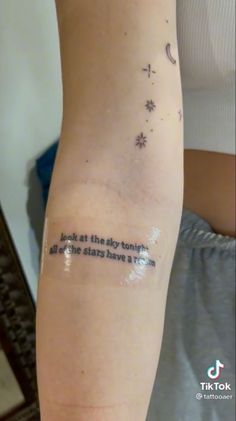 a person with a tattoo on their arm that says, look at the sky tonight all this stars have fallen