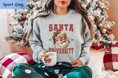 Santa University Christmas Shirt, Funny Christmas Sweatshirt, Santa Squad Shirt, Holiday Sweater, Retro Santa Tee, Christmas Vacation Shirt Product Informations  🎯  👕 T-shirts & Long Sleeve T-shirts: Solid Colors (black, white, pink): 100% Cotton Heather Colors: 52% Cotton, 48% Polyester 👚 Sweatshirts: Solid Colors (black, white, maroon): 50% Cotton, 50% Polyester Heather Colors: 40% Cotton, 60% Polyester ➕👕 How to Order Multiple Items 🛒 Select your size and color from the dropdown options and add them to your cart. Repeat the process for each additional shirt. If you wish to modify the existing design shown in the display picture, please contact us. 📝 Policy Information Each shirt is custom-made for you. Due to this personalized approach, returns or exchanges are not accepted. To en Christmas Vacation Shirt, Christmas Vacation Shirts, Santa Tee, Christmas Shirt Funny, Retro Santa, Squad Shirt, Display Picture, Funny Christmas Shirts, Christmas Vacation