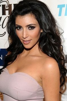 a woman in a strapless dress poses for the camera on a red carpet at an event