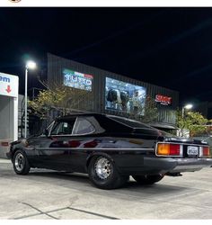 a black car parked in front of a gas station