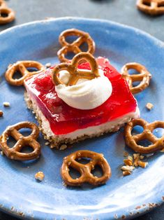 a blue plate topped with a piece of cake covered in pretzels and marshmallows