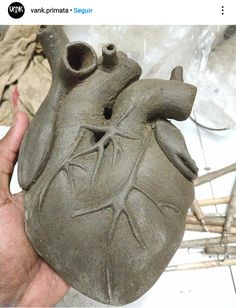 a person holding a clay heart in their hand