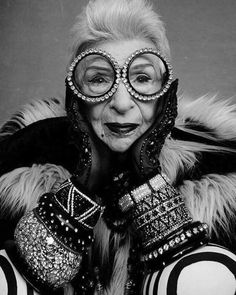 an old woman with large glasses and gloves on her face, posing for the camera