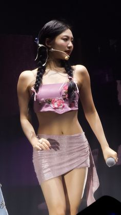 a woman in a pink top and skirt on stage