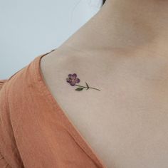 a small purple flower on the back of a woman's neck