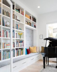 a living room filled with lots of furniture and bookshelves next to a piano