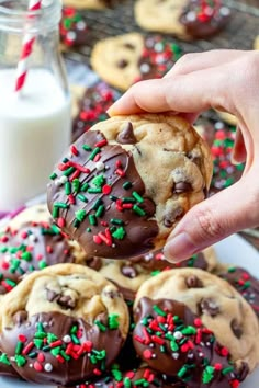 chocolate chip cookies with sprinkles are being held up by someone's hand