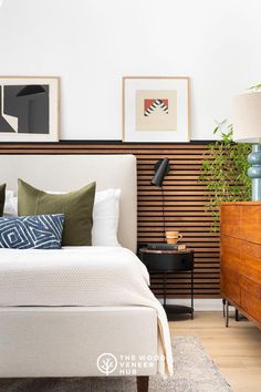 a white bed sitting in a bedroom next to a wooden dresser