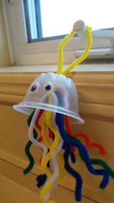 a plastic jellyfish hanging from a window sill