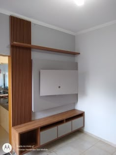 an empty living room with white walls and wooden shelves