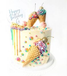 a birthday cake decorated with ice cream cones and sprinkles on a white plate