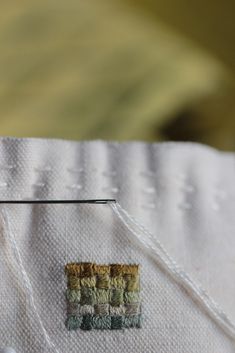 a close up of a piece of cloth with some thread on it and a needle in the middle