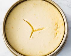 a close up of a cake in a pan on a white counter top with a clock