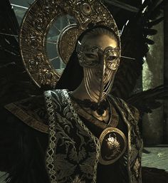 a woman dressed in black and gold with wings on her head