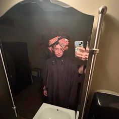 a person taking a selfie in a bathroom mirror