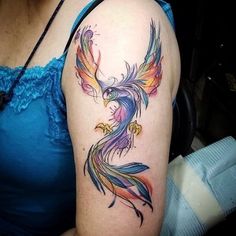 a woman with a colorful bird tattoo on her arm